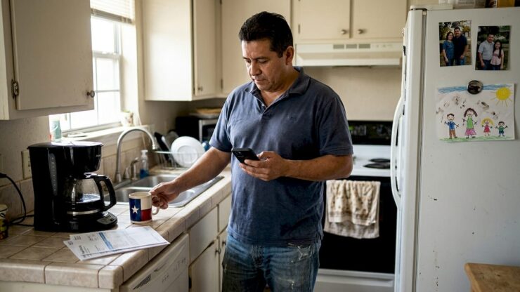 Man checks prepaid electricity on phone in kitchen