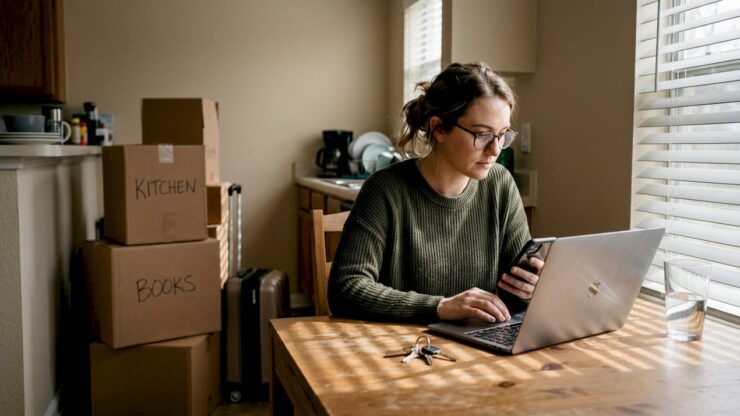 Woman at kitchen table signing up for electricity